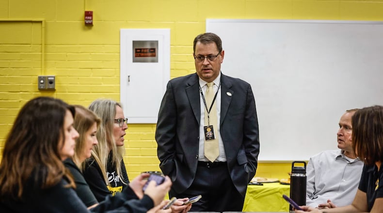 Centerville superintendent Jon Wesney talks to Centerville administrators before heading to the polls to check the outcome. Centerville precincts post results on the doors of polling places. Jim Noelker/Staff