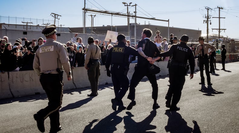 FILE — Police officers detain a faith leader at a protest in front of a U.S. Immigration and Customs Enforcement facility in Broadview, Ill., Nov. 14, 2025. A federal judge has ordered the Trump administration to allow Roman Catholic clergy members to minister to people at a detention center near Chicago on Ash Wednesday, after they had been denied access for months. (Jamie Kelter Davis/The New York Times)