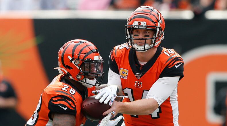 Cincinnati Bengals quarterback Andy Dalton (14) hands the ball to running back Joe Mixon (28) in the first half of an NFL football game against the Arizona Cardinals, Sunday, Oct. 6, 2019, in Cincinnati. (AP Photo/Gary Landers)