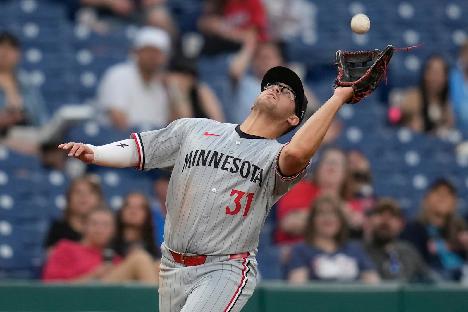 Minnesota Twins first baseman Jonah Bride (31) catches a fly ball hit for an out by Cleveland Guardians' Brayan Rocchio in the fifth inning of a baseball game in Cleveland, Monday, April 28, 2025. (AP Photo/Sue Ogrocki)