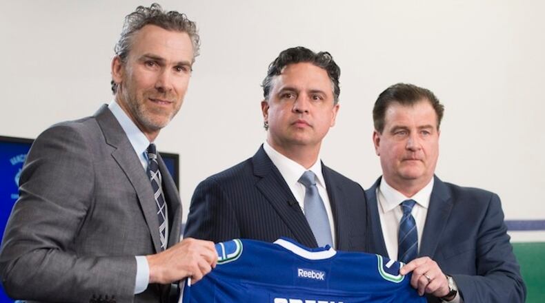 In this April 26, 2017, file photo, Vancouver Canucks president Trevor Linden, left, and general manager Jim Benning, right, introduce the Canucks new head coach Travis Green during a news conference in Vancouver, British Columbia. Three of the six NHL coaching vacancies this offseason were filled by first-timers as teams look to find the next new idea rather than recycling the past. (Jonathan Hayward/The Canadian Press via AP, File)