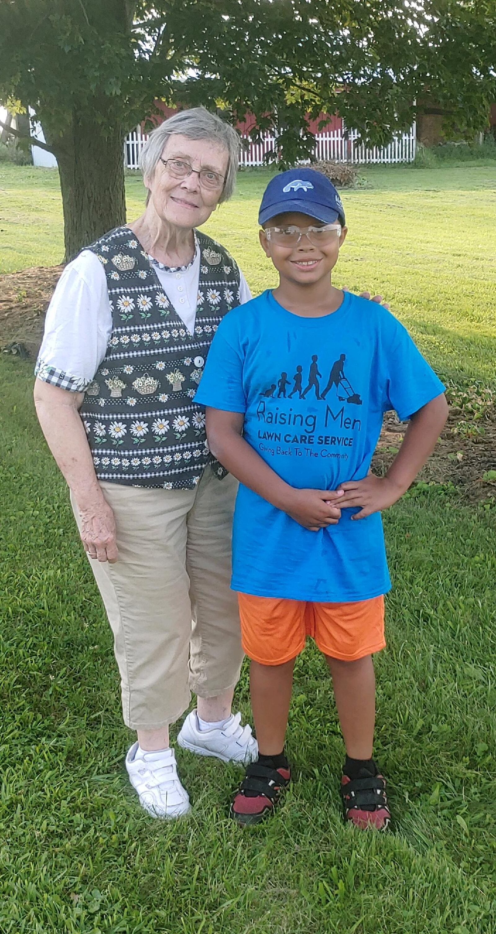 Adian Harris, right, a nine-year-old West Alexandria boy, mowed lawns all summer as part of a challenge to mow 50 lawns for the elderly, disabled, single parents or veterans. Pictured with Harris is Marti Eley-Paul of Lewisberg, one of the people whose lawns he mowed. COURTESY OF RON ROBERT