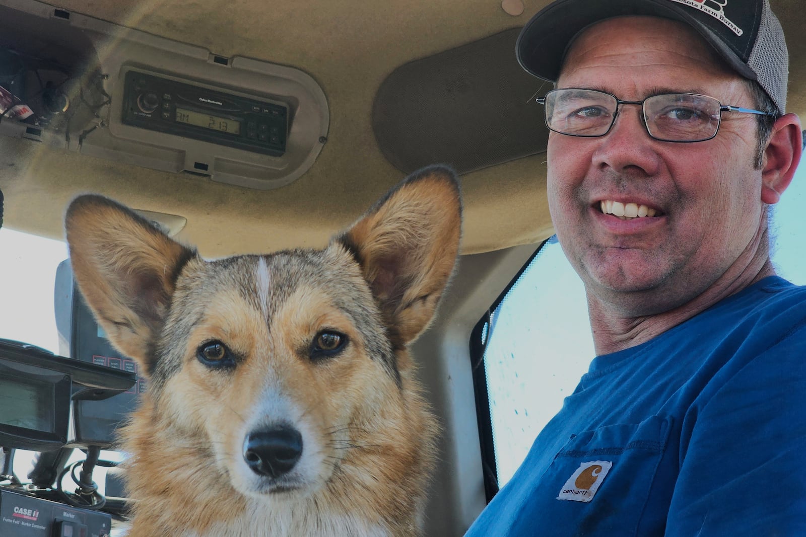 Minnesota farmer Dan Glessing and his corgi, Georgie, are shown in his tractor as they prepare to take a break from planting soybeans on Thursday, May 9, 2025, near Waverly, Minn. (AP Photo/Steve Karnowski)