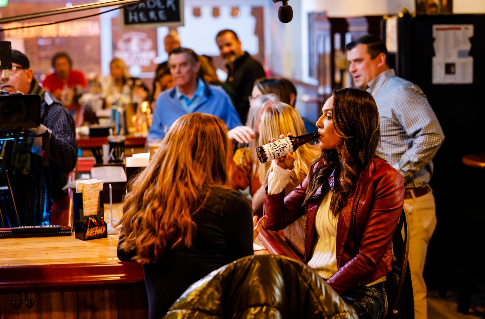 United Front Films along with M5 Entertainment, cast and local extras film scenes for the movie "A Bachelor's Valentine" Wednesday, Jan. 26, 2022 at White Dog Saloon & Distilling Company in Middletown. Laura Radi, playing Jessica Bachelor, left, and Layla Cushman, playing Claire Knapp, sit at the bar during a scene. NICK GRAHAM / STAFF