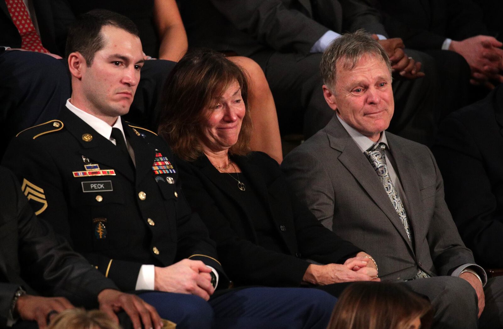 WASHINGTON, DC - JANUARY 30:  Army Staff Sergeant Justin Peck sits with Fred and Cindy Warmbier during the State of the Union address in the chamber of the U.S. House of Representatives January 30, 2018 in Washington, DC. This is the first State of the Union address given by U.S. President Donald Trump and his second joint-session address to Congress.  (Photo by Alex Wong/Getty Images)