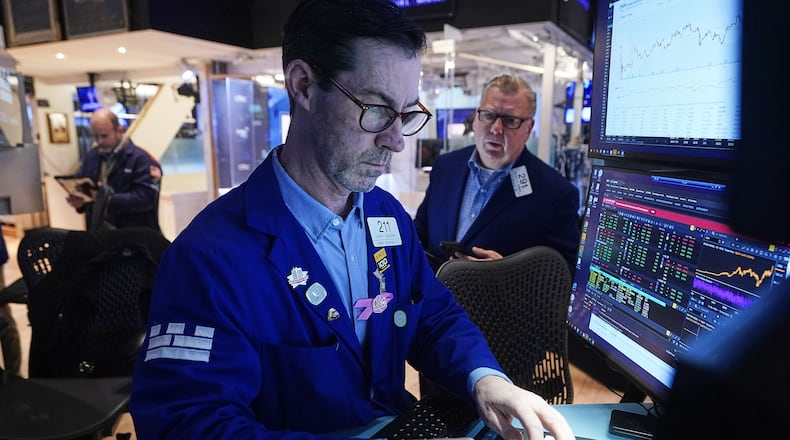 Specialist John McNierney, center, and trader Mathias Roberts, right, work on the floor of the New York Stock Exchange, Tuesday, Feb. 10, 2026. (AP Photo/Richard Drew)