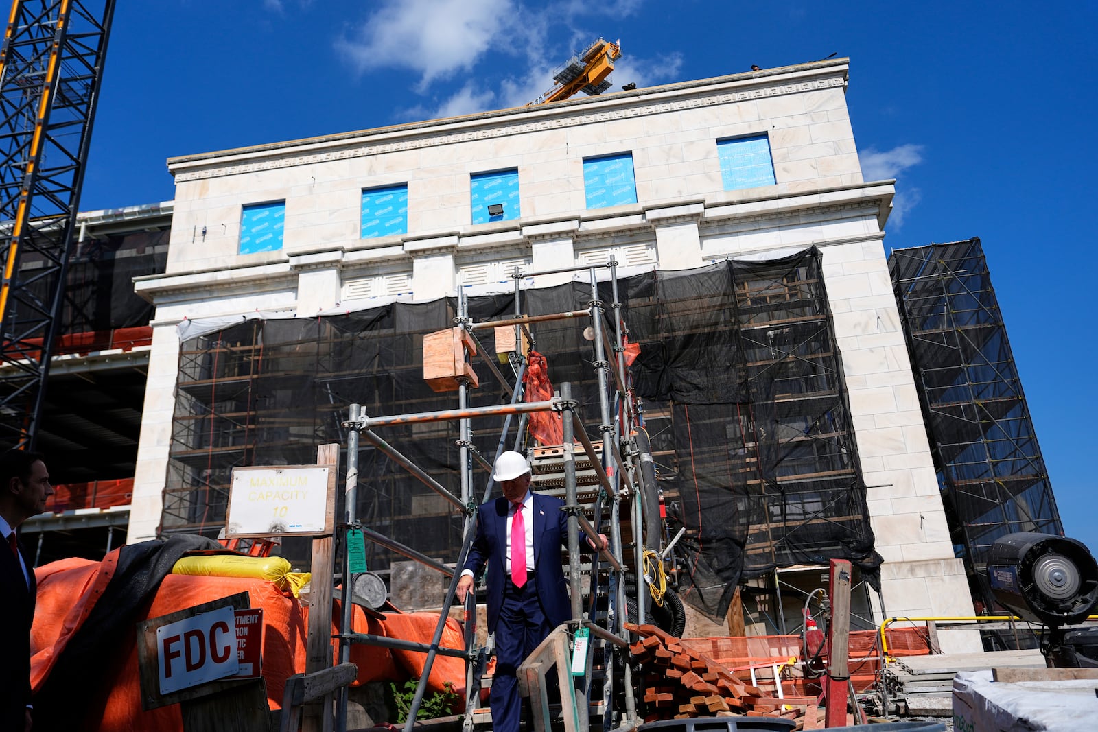 President Donald Trump walks down stairs as he visits the Federal Reserve during renovations, Thursday, July 24, 2025, in Washington. (AP Photo/Julia Demaree Nikhinson)