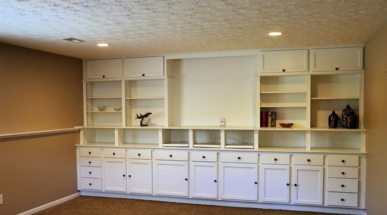 One wall of the lower level family room has a built-in entertainment center with media outlets, cabinetry and bookcases. Off the family room is a possible fourth bedroom as the room has a closet and daylight window, a third full bathroom and the laundry room.