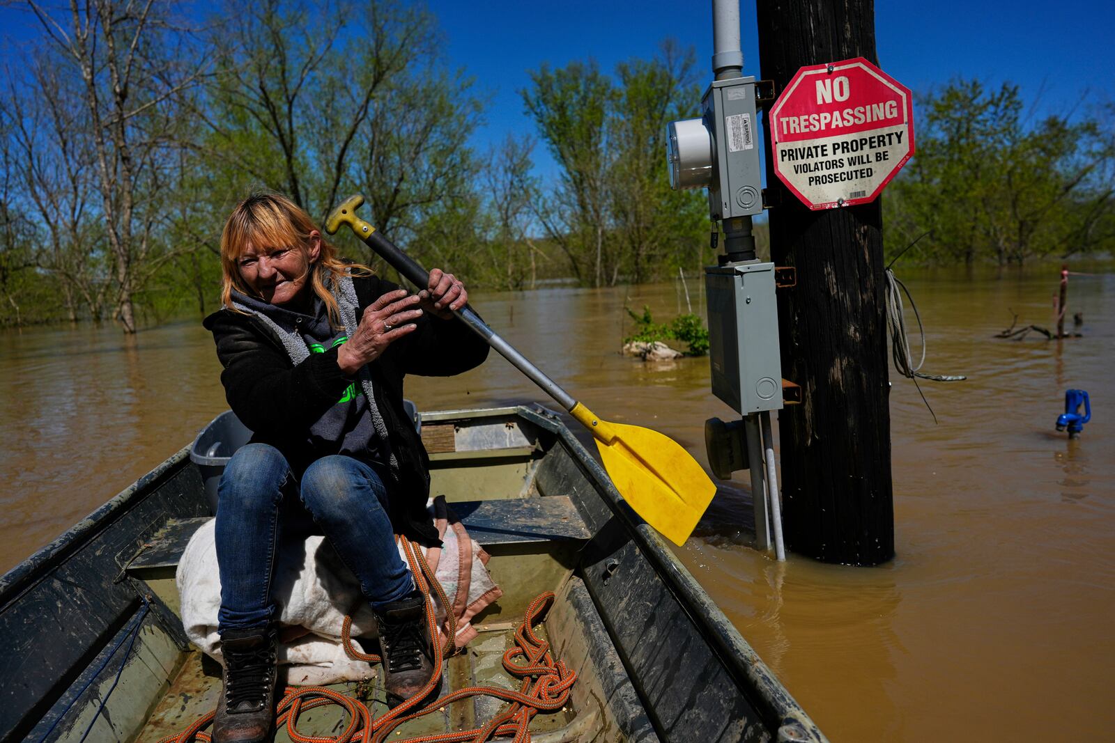 Resident Wanona Harp paddles past a utility pole in Lockport, Ky., flooded by the Kentucky River, Tuesday, April 8, 2025. (AP Photo/Carolyn Kaster)