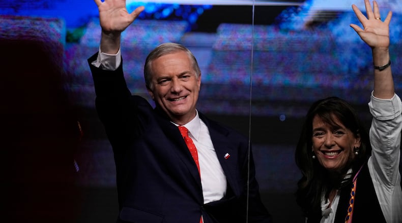 Presidential candidate Jose Antonio Kast of the Republican Party, and his wife Maria Pia Adriasola, wave to supporters after early results in the general elections in Santiago, Chile, Sunday, Nov. 16, 2025. (AP Photo/Esteban Felix)