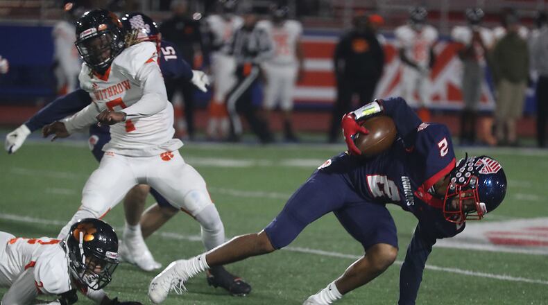 Piqua's Dresean Roberts tries to stay on his feet after being tripped up by Withrow's Artrimus Sartor during a Division II, Region 8 playoff game on Nov. 5, 2021. BILL LACKEY/STAFF