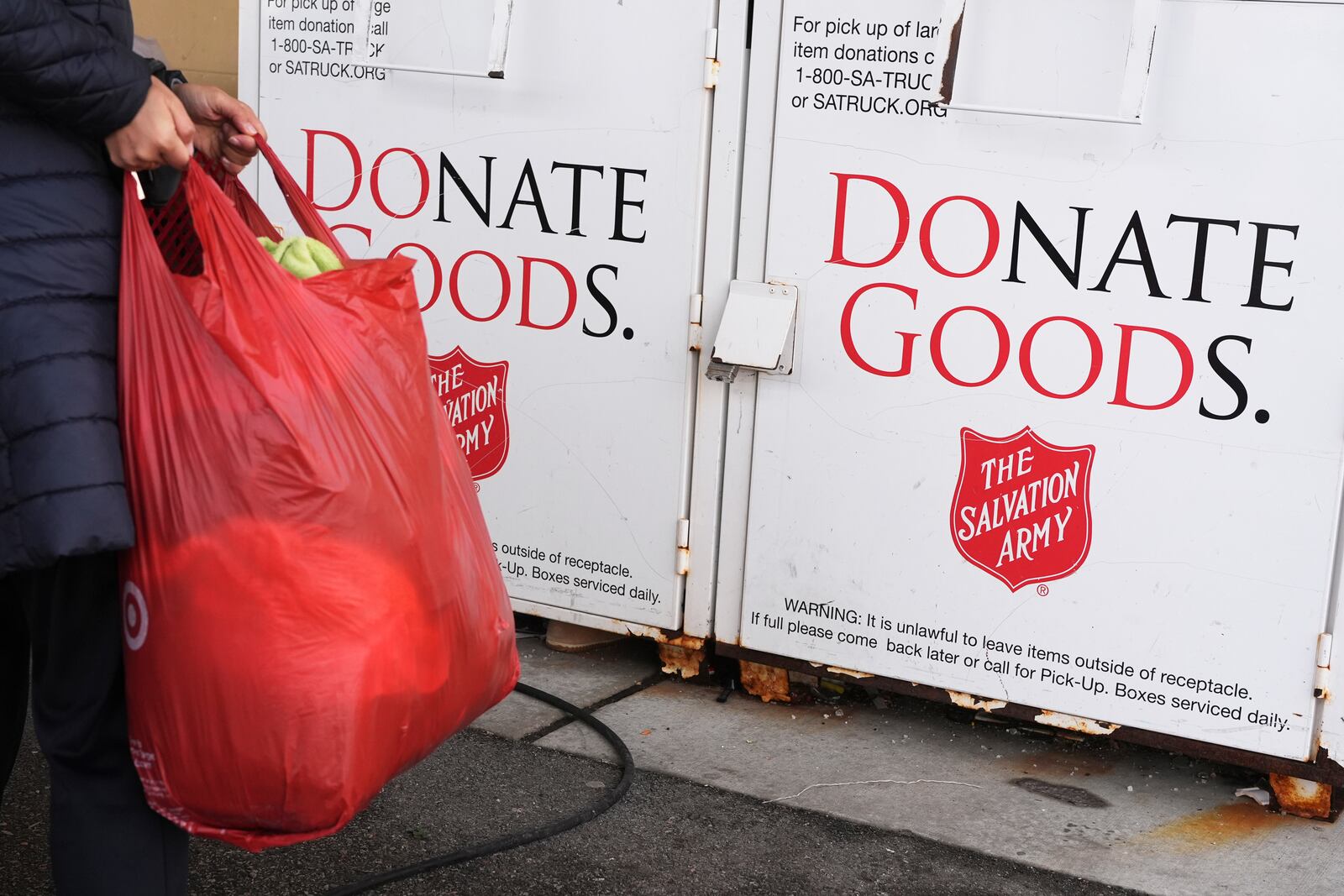 FILE - A woman carries a bag to donation center of the Salvation Army in Glenview, Ill., Thursday, Jan. 11, 2024. (AP Photo/Nam Y. Huh, File)