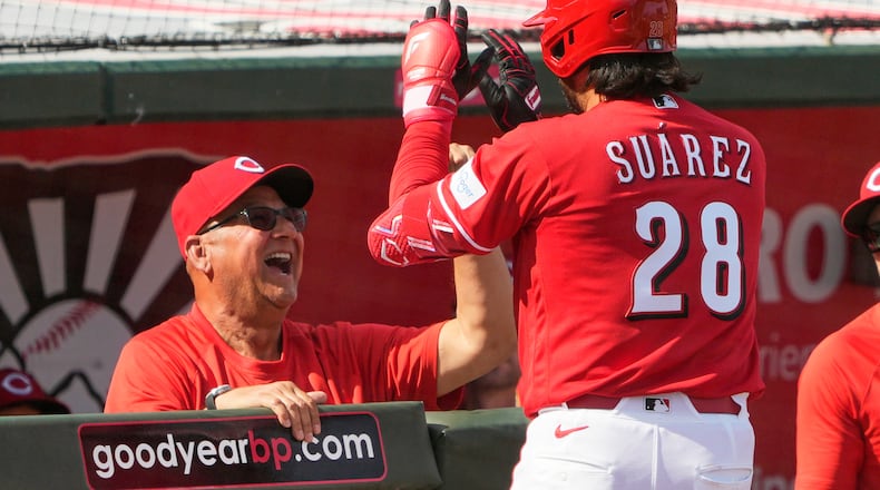 Cincinnati Reds' Eugenio Suárez celebrates in the dugout after scoring with manager Terry Francona against the Kansas City Royals during the fifth inning of a spring baseball game in Goodyear, Ariz., Tuesday, Feb. 24, 2026. (AP Photo/Chris Carlson)