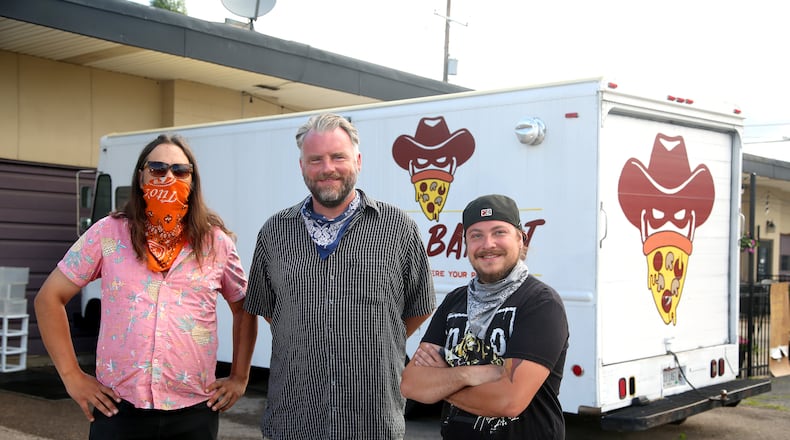 Brian Johnson, Mark Jeffers and James Burton (left to right) are the owners of the Pizza Bandit, a New York style pizza truck that can found at the Yellow Cab Tavern in Dayton. LISA POWELL / STAFF