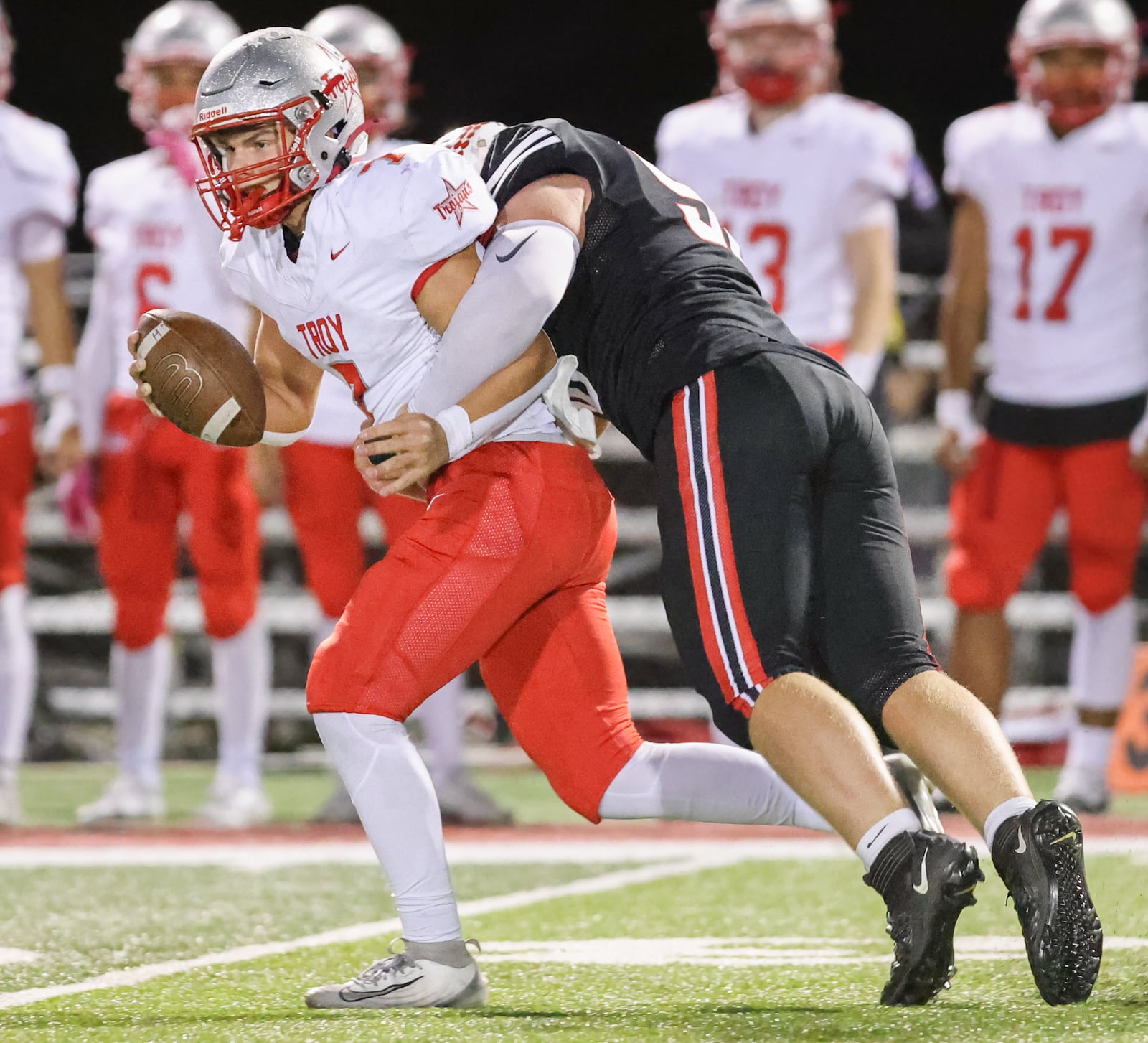 Troy senior quarterback Aiden Kirkpatrick is tackled by Tippecanoe's Ryan Kolb during the second quarter of a Miami Valley League game on Friday, Oct. 17 at Tipp City Park. BRYANT BILLING / STAFF