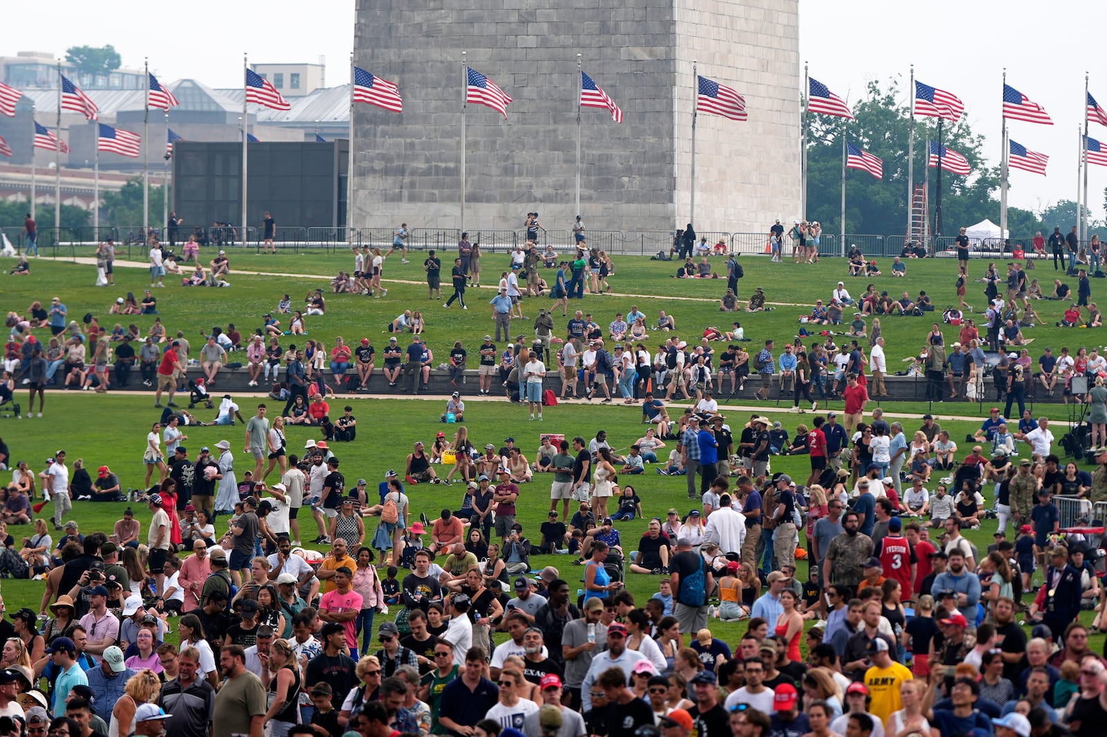 People on the lawn around the Washington Monument as President Donald Trump attends a military parade commemorating the Army's 250th anniversary, coinciding with his 79th birthday, Saturday, June 14, 2025, in Washington. (AP Photo/Julia Demaree Nikhinson)