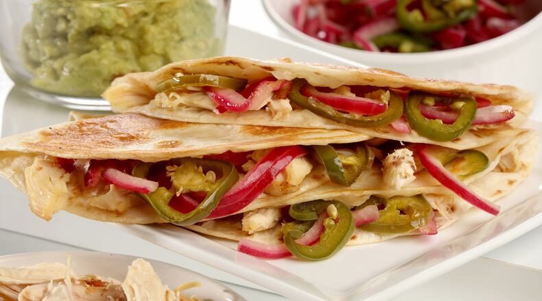 Chicken quesadillas are brightened with quick-pickled red onion and jalapenos and enriched with cheese, all folded into a tortilla. (Michael Tercha/Chicago Tribune/TNS)