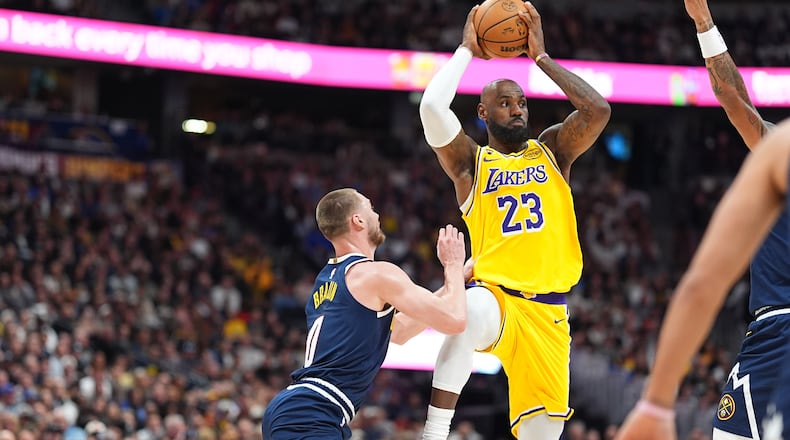 Los Angeles Lakers forward LeBron James, right, passes the ball as Denver Nuggets guard Christian Braun defends in the first half of an NBA basketball game, Thursday, March 5, 2026, in Denver. (AP Photo/David Zalubowski)