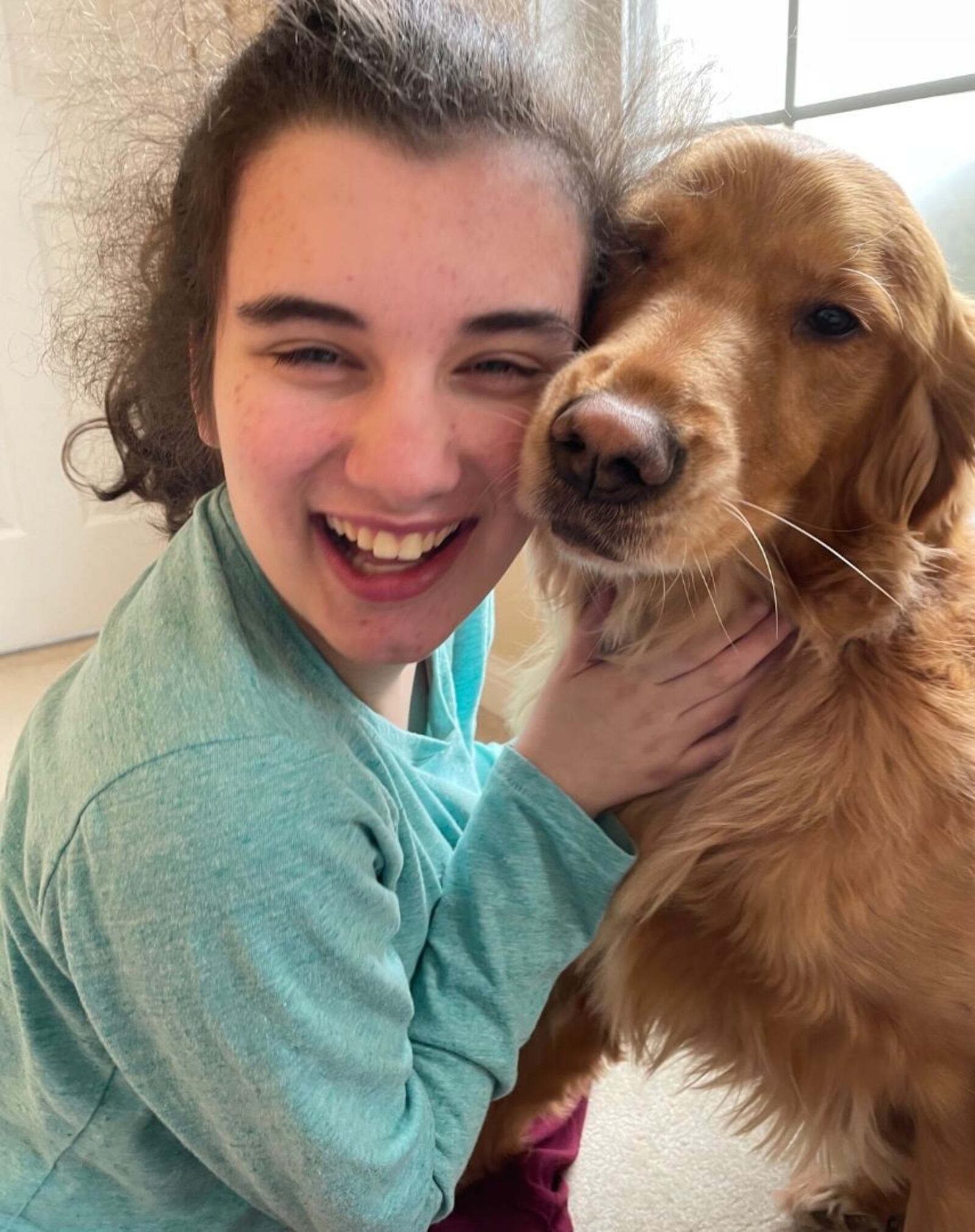 Mimi Sodano hugs her dog, Molly. Mimi requires specialized care because of a rare neurodevelopmental disorder. Photo provided by Lindsey Sodano.