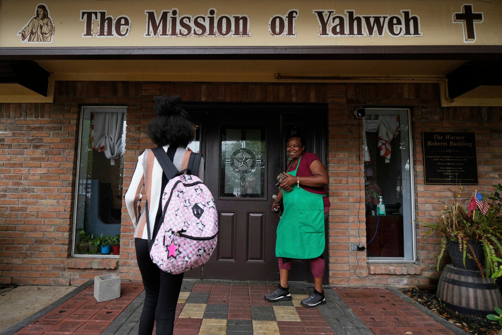 Crystal Holmes, right, greets her granddaughter, Mackenzie Holmes, 10, as she arrives at Mission of Yahweh women's shelter after school on Tuesday, April 1, 2025, in Houston. (AP Photo/Ashley Landis)
