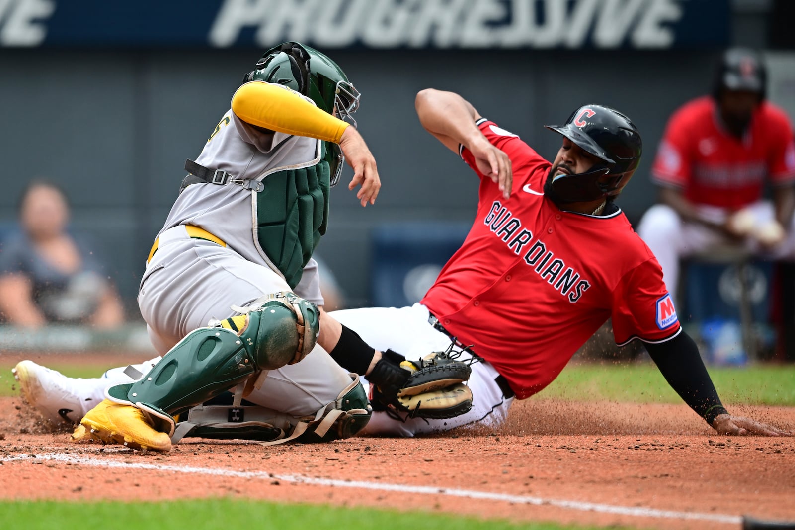 Athletics catcher Shea Langeliers tags out Cleveland Guardians outfielder Johnathan Rodríguez at home plate during the fourth inning of a baseball game, Sunday, July 20, 2025, in Cleveland. (AP Photo/David Dermer)