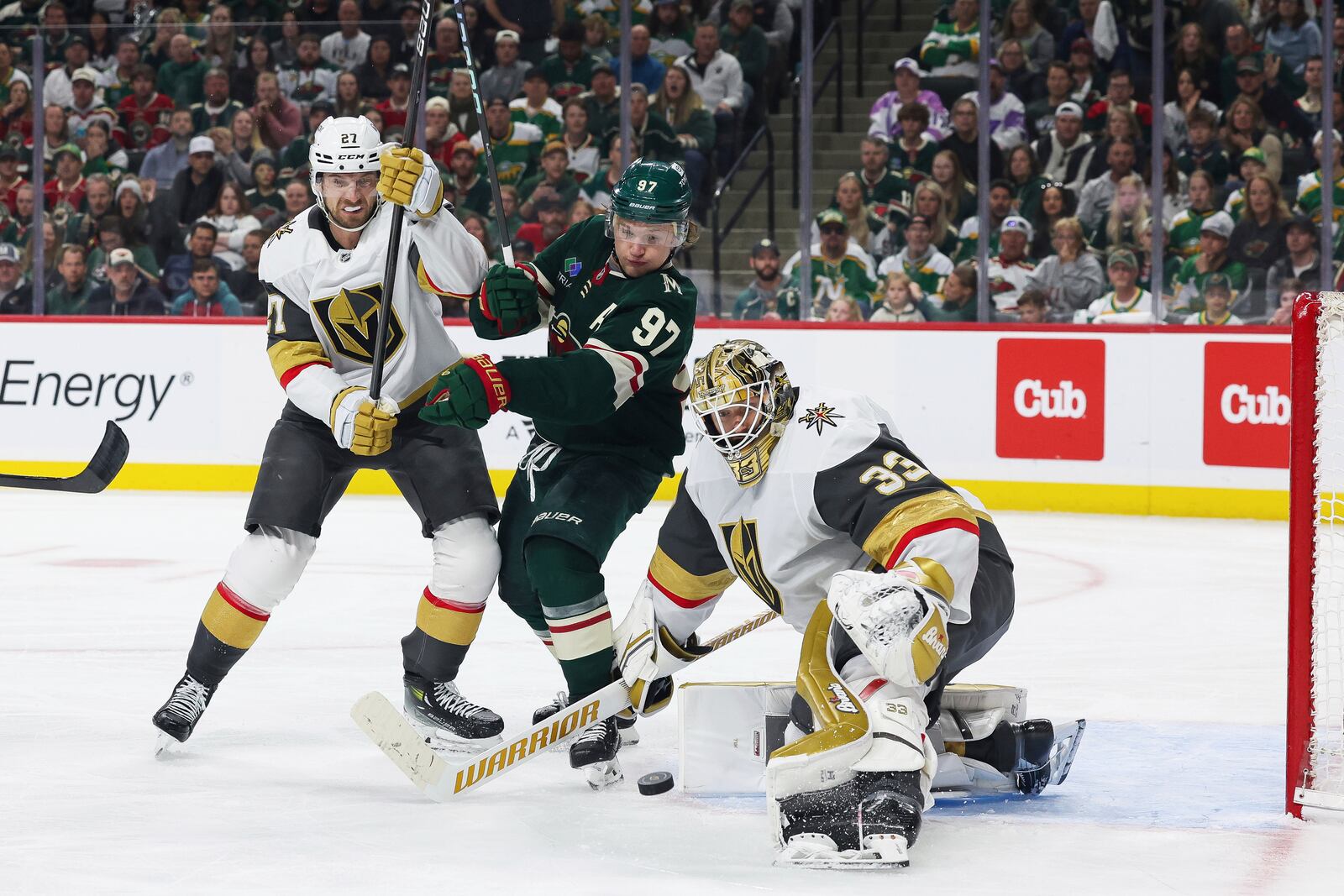 Minnesota Wild left wing Kirill Kaprizov (97) and Vegas Golden Knights defenseman Shea Theodore (27) fight for control of the puck during the third period in Game 4 of an NHL hockey Stanley Cup first-round playoff series, Saturday, April 26, 2025, in St. Paul, Minn. (AP Photo/Stacy Bengs)