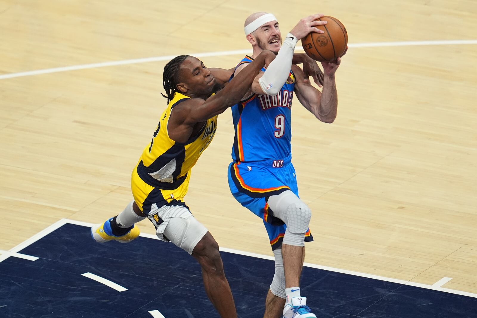 Oklahoma City Thunder guard Alex Caruso (9) drives as Indiana Pacers forward Aaron Nesmith defends during the second half of Game 3 of the NBA Finals basketball series, Wednesday, June 11, 2025, in Indianapolis. (AP Photo/Michael Conroy)