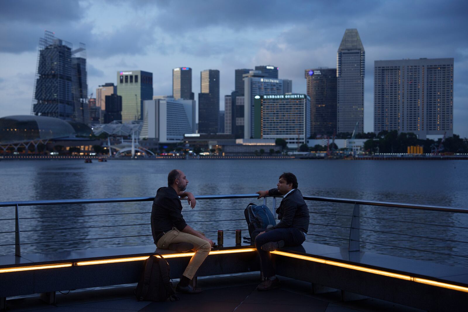 FILE - People talk along the bay in the evening in Singapore, on May 30, 2024. (AP Photo/Vincent Thian, File)