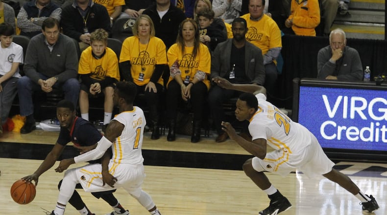Daytonâs Scoochie Smith brings the ball up the court against Virginia Commonwealthâs JeQuan Lewis (1) and Treveon Graham, far right, on Saturday, Feb. 28, 2015, at the Siegel Center in Richmond, Va. David Jablonski/Staff