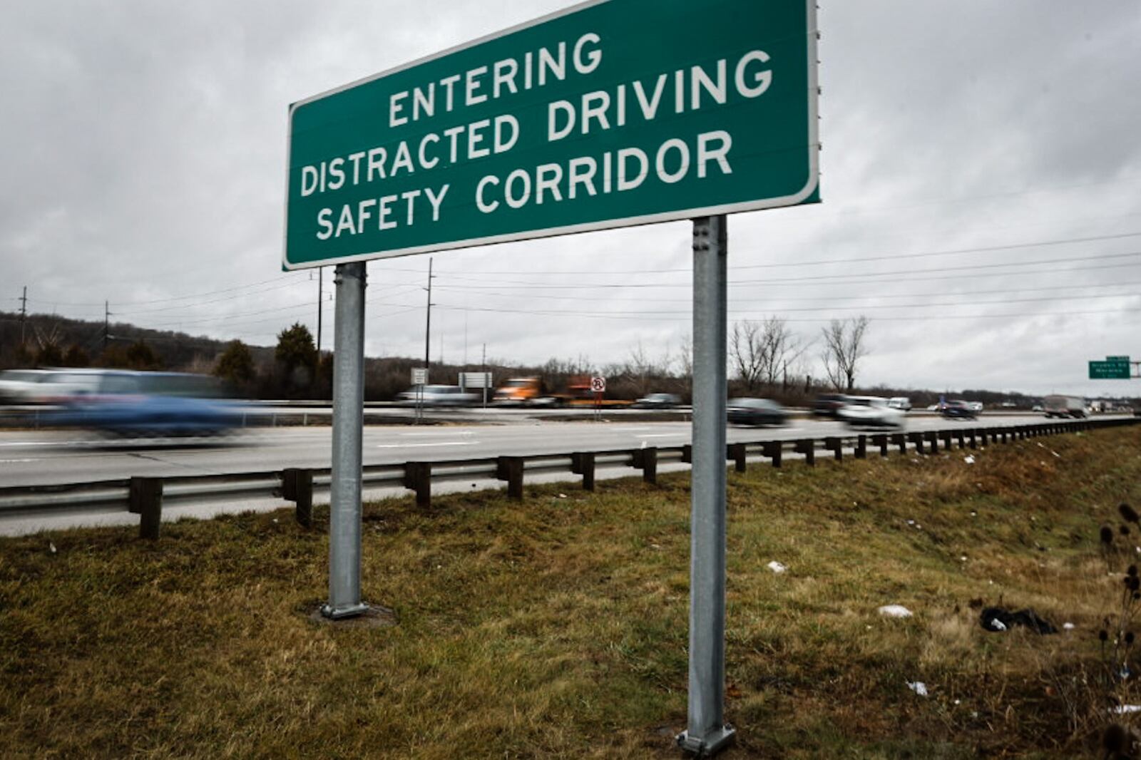 A large sign on the northbound side of Interstate 75 near West Carrollton warns drivers they are entering a distracted driving safety corridor.  Gov. Mike DeWine signed a bill Tuesday morning limiting the use of electronic devices while driving. JIM NOELKER/STAFF