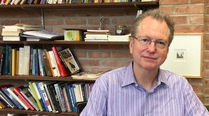 Tom Manley, president of Antioch College in Yellow Springs, sits in his office near a bookcase. Manley has led the college for a little over a year now.