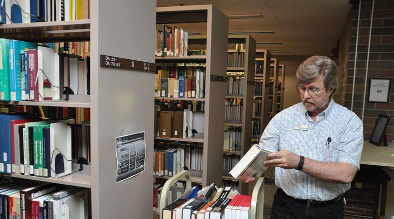 Dwight Goforth, a library technician at the D’Azzo Research Library, places books back into circulation. Today, the library includes more than 1 million items. (U.S. Air Force photo/Bryan Ripple)