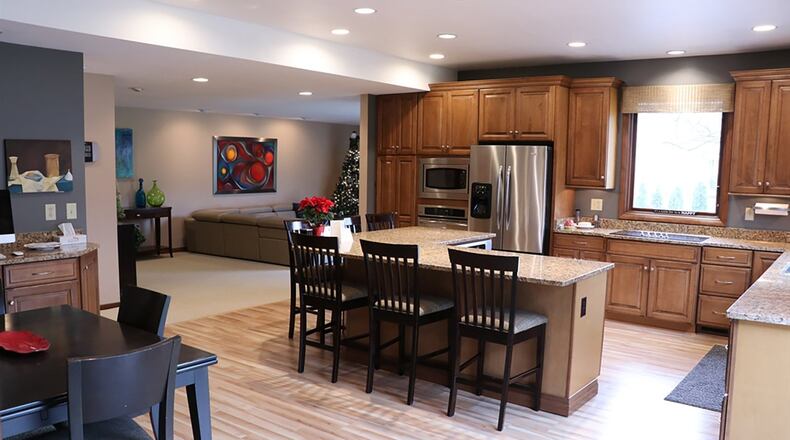 After expansion and renovation of the kitchen, the centerpiece is a granite L-shaped island with outer seating for at least 6 people who can face the chef at the center of its inner space with multiple under-cabinets and an under-counter oven at hand.