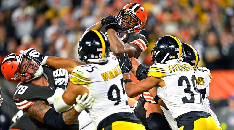 Cleveland Browns running back Nick Chubb, top, leaps into the end zone for a touchdown during the second half of the team's NFL football game against the Pittsburgh Steelers in Cleveland, Thursday, Sept. 22, 2022. (AP Photo/David Richard)