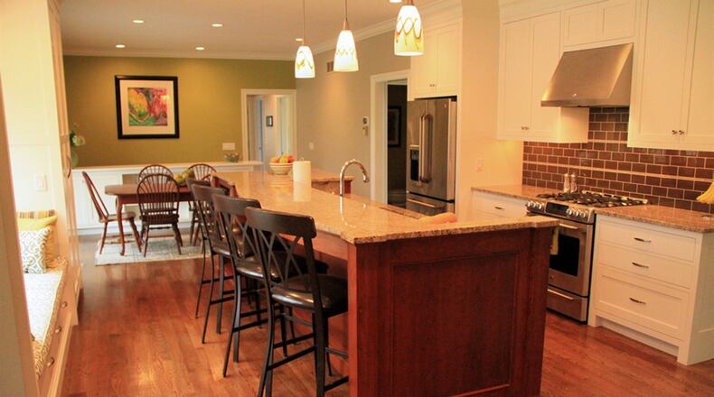 Granite tops all the counters, including a 12-foot-long center island, which provides a breakfast bar tiered above a wide counter space that holds an under-mounted sink with a gooseneck faucet.