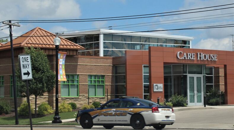 A Trotwood police officer drives by CARE House in Old North Dayton. CORNELIUS FROLIK / STAFF