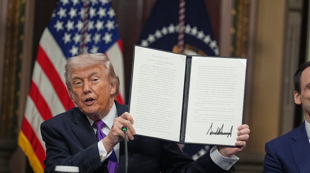 President Donald Trump holds up the Ratepayer Protection Pledge after signing it in the Indian Treaty Room of the Eisenhower Executive Office Building on the White House complex, Wednesday, March 4, 2026, in Washington. (AP Photo/Jacquelyn Martin)