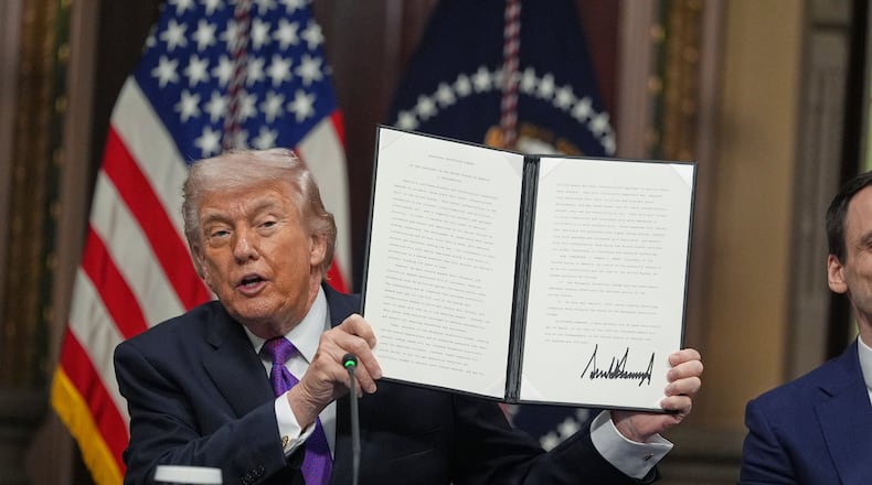 President Donald Trump holds up the Ratepayer Protection Pledge after signing it in the Indian Treaty Room of the Eisenhower Executive Office Building on the White House complex, Wednesday, March 4, 2026, in Washington. (AP Photo/Jacquelyn Martin)