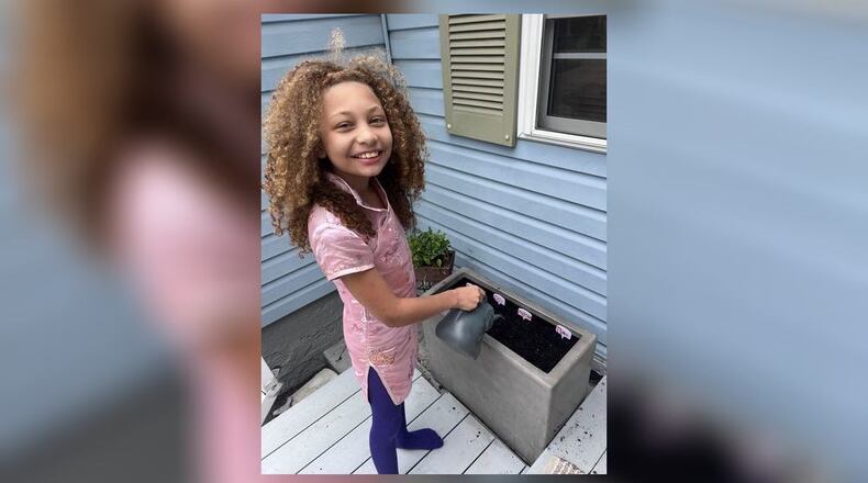 Jasmine watering our herb garden. CONTRIBUTED
