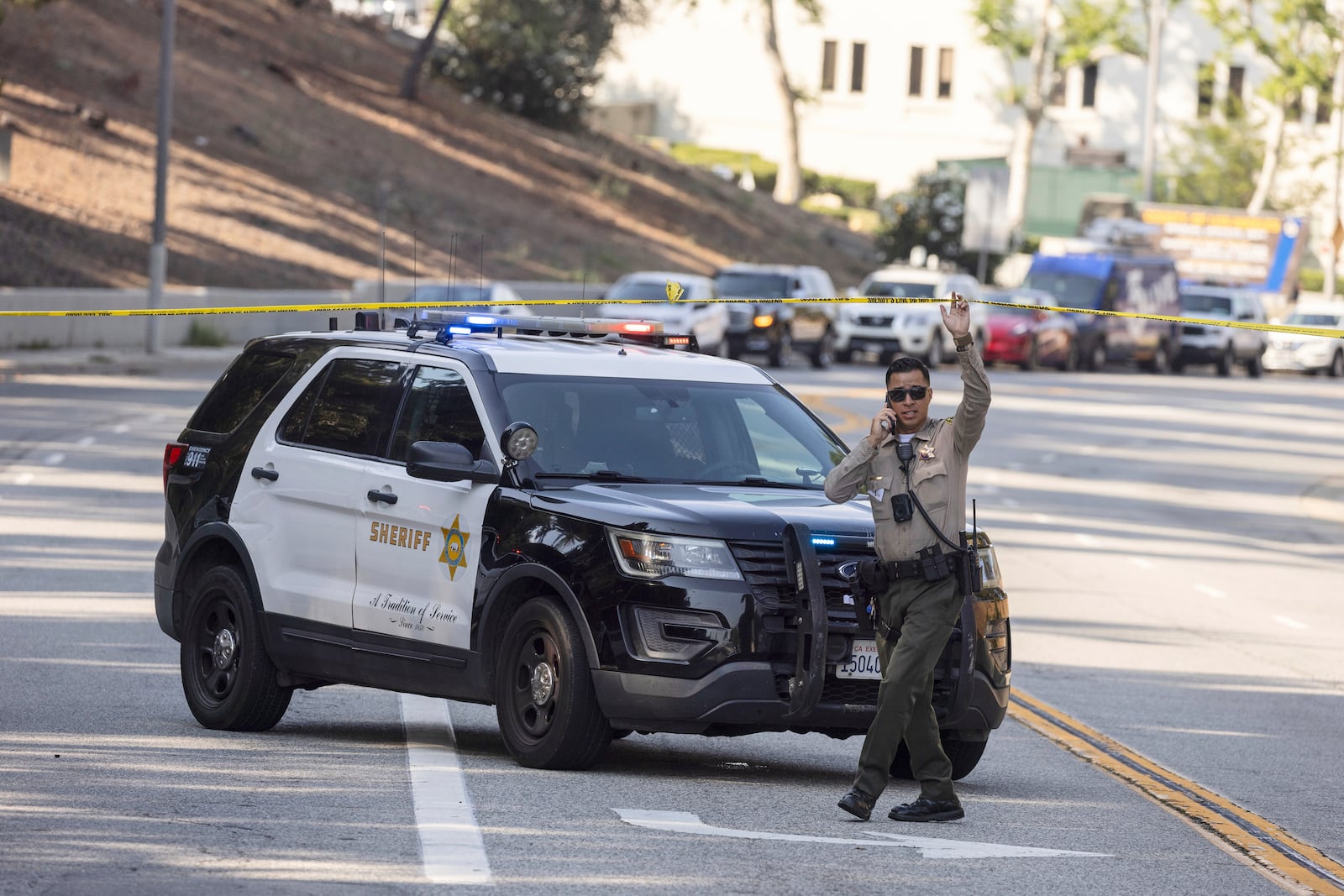 A sheriffs deputy monitors a street closure near the site of an explosion at the LA County Sheriff's Special Operations Bureau on Friday, July 18, 2025, in Los Angeles. (AP Photo/Etienne Laurent)