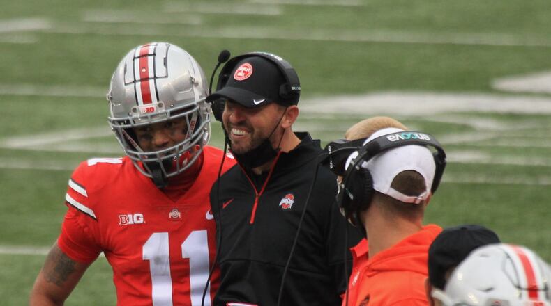 Ohio State wide receiver Jaxon Smith-Njigba celebrates a touchdown with coach Brian Hartline against Nebraska on Saturday, Oct. 24, 2020, at Ohio Stadium in Columbus. David Jablonski/Staff
