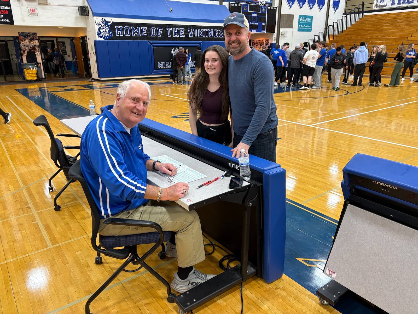 Miamisburg High School boys basketball scorekeeper Ron Anslinger poses for a photo with his son Bryce and granddaughter Oakley after the Vikings game against Kings on Feb. 17, 2026. TOM ARCHDEACON / CONTRIBUTED PHOTO