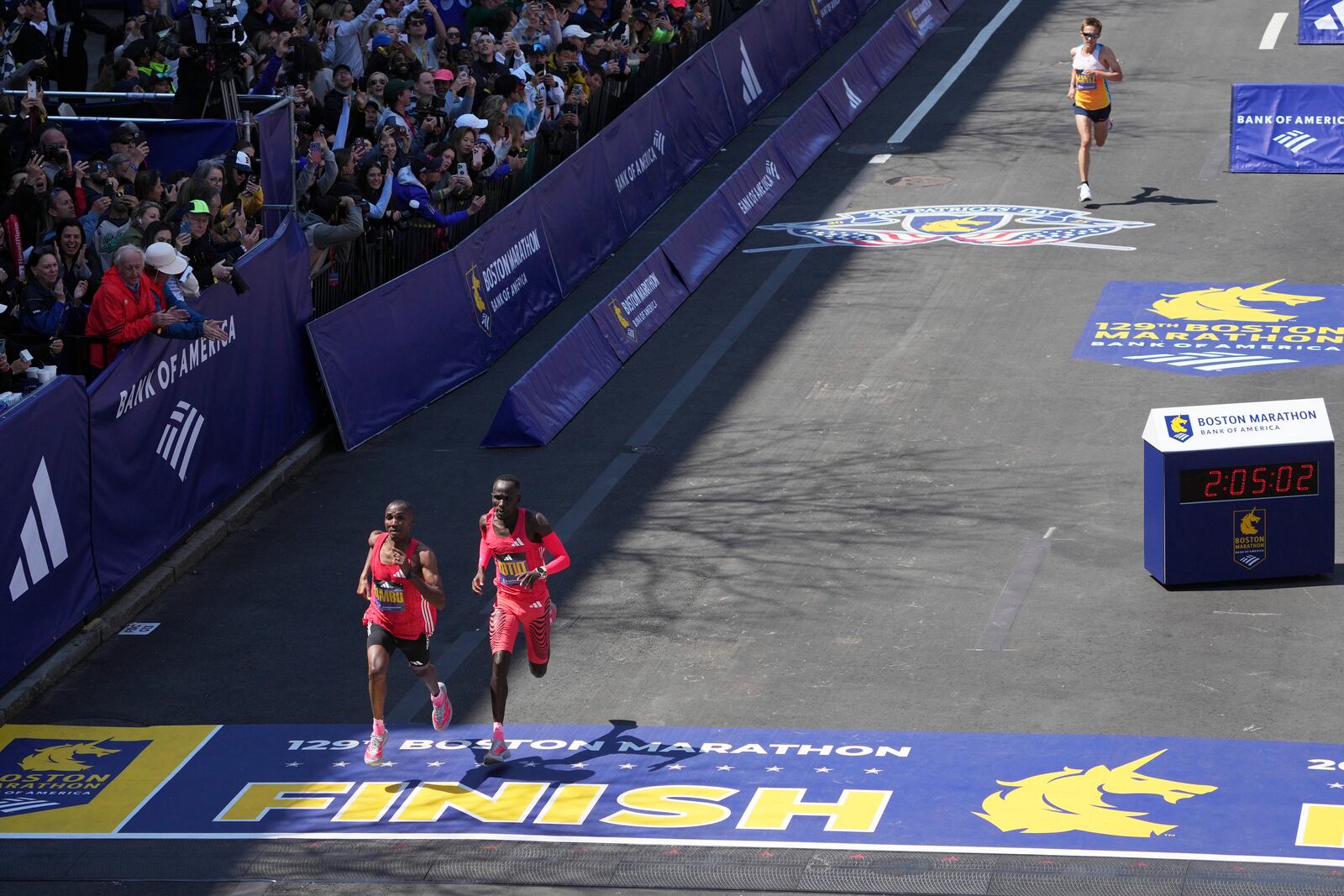 Conner Mantz, of the United States, top right, chases Alphonce Felix Simbu, left, and Cybrian Kotut towards the finish line during the Boston Marathon, Monday, April 21, 2025, in Boston. (AP Photo/Charles Krupa)