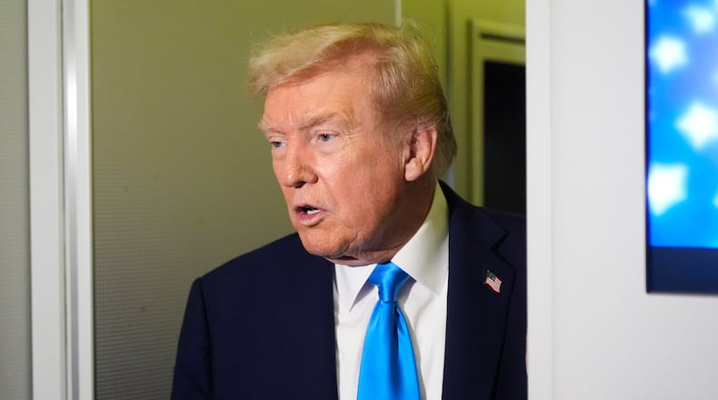 President Donald Trump speaks with reporters aboard Air Force One at Al Udeid Air Base in Doha, Qatar, Saturday, Oct. 25, 2025. (AP Photo/Mark Schiefelbein)