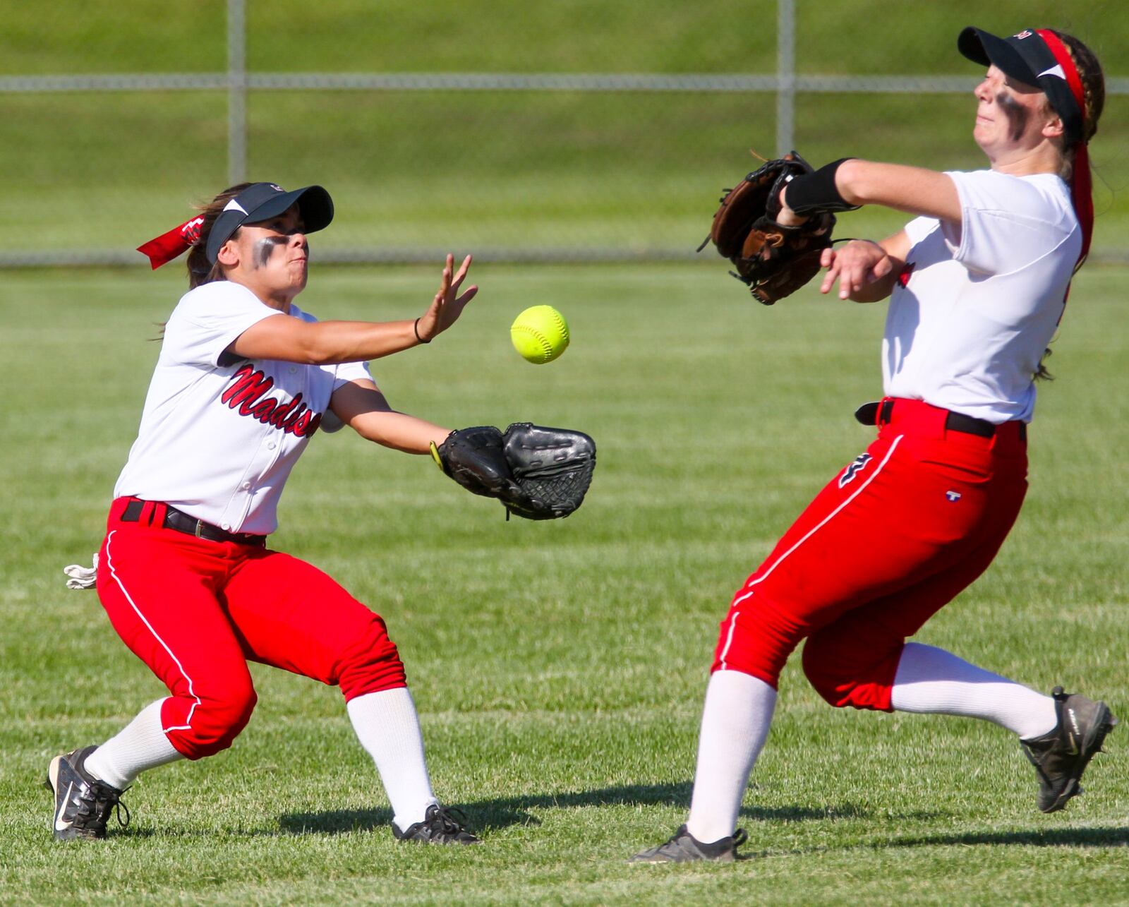 Madison left fielder Maggie Schenck (3) and shortstop Jenna O’Hair (4) nearly colide on a short fly ball during their Division III sectional final against Carlisle on Monday at Fenwick. GREG LYNCH/STAFF