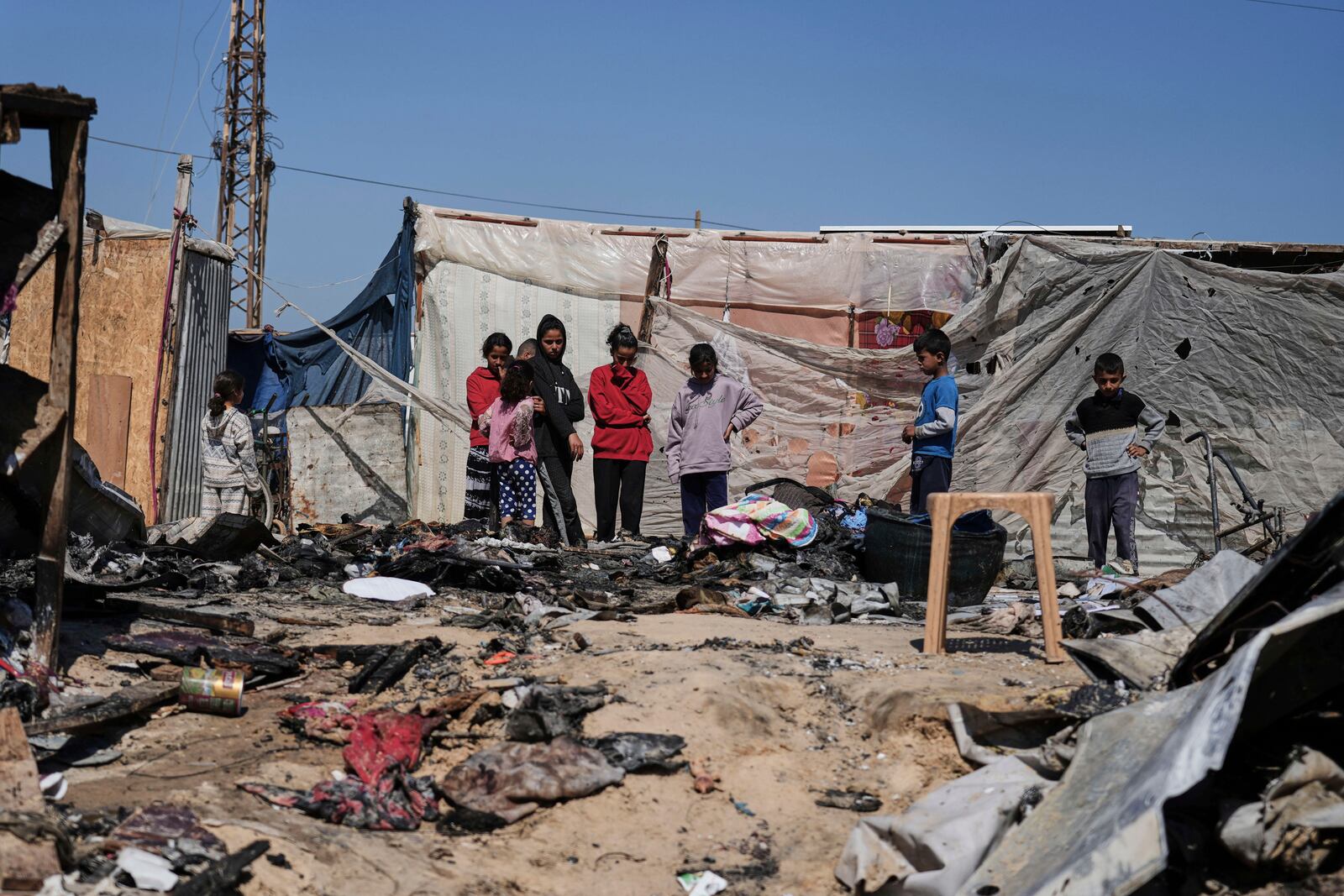 Palestinians inspect the remains of a displacement tent hit by an Israeli airstrike overnight, killing 10 members of the Abu Al-Rous family, in Khan Younis, southern Gaza Strip, Thursday, April 17, 2025. (AP Photo/Abdel Kareem Hana)