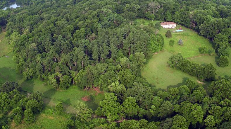The Kircher family is looking to create Bellbrook Mountain snowtubing, skiing, snowboarding and sledding on family land that includes a steep wooded hillside already carved with trails. This aerial view looking west shows the hillside. TY GREENLEES / STAFF