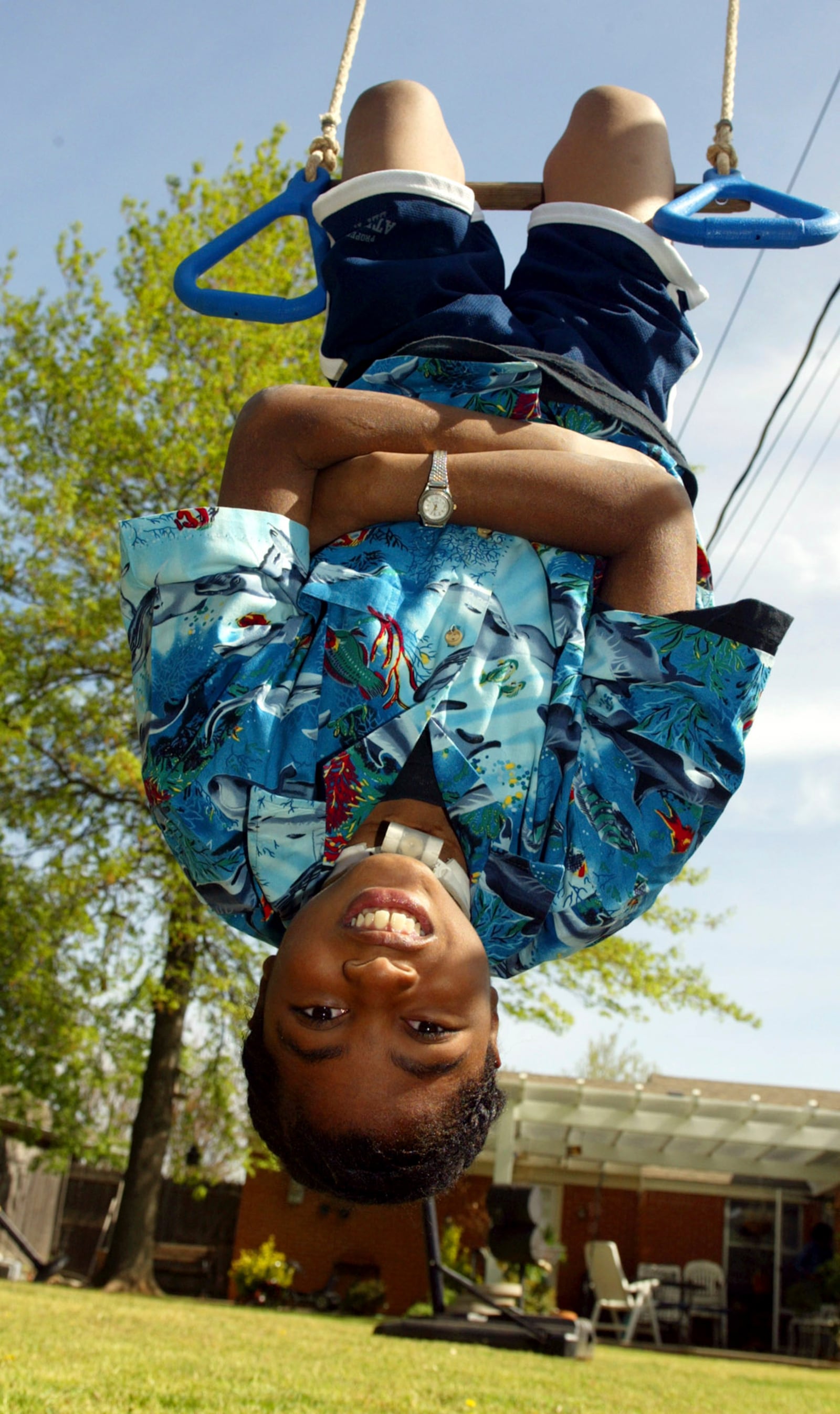 FILE - Nine-year-old P.J. Allen plays in his backyard in Oklahoma City on April 17, 2003. One of the youngest survivors of the Oklahoma City bombing, Allen says he wants more than anything to be able to swim and wrestle with his friends without worrying about the tracheotomy in his throat getting dislodged. (AP Photo/Sue Ogrocki, File)