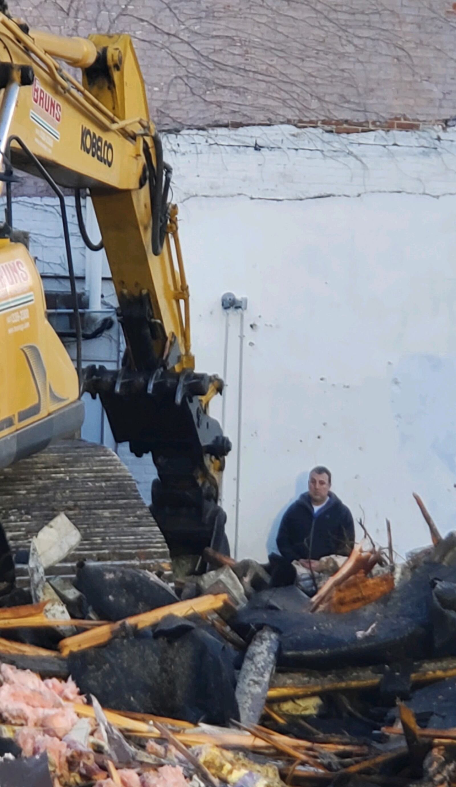 Troy Historic Preservation Alliance member Ben Sutherly stands in front of a bulldozer at the Troy Tavern building on Wednesday morning, March 29, 2023. CONTRIBUTED PHOTO