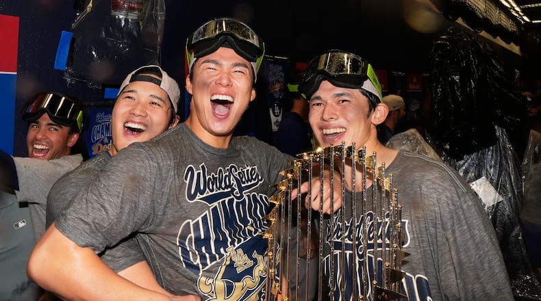 Los Angeles Dodgers pitcher Shohei Ohtani, pitcher Yoshinobu Yamamoto and pitcher Roki Sasaki celebrate after their win against the Toronto Blue Jays in Game 7 of baseball's World Series, Sunday, Nov. 2, 2025, in Toronto. (AP Photo/Brynn Anderson)